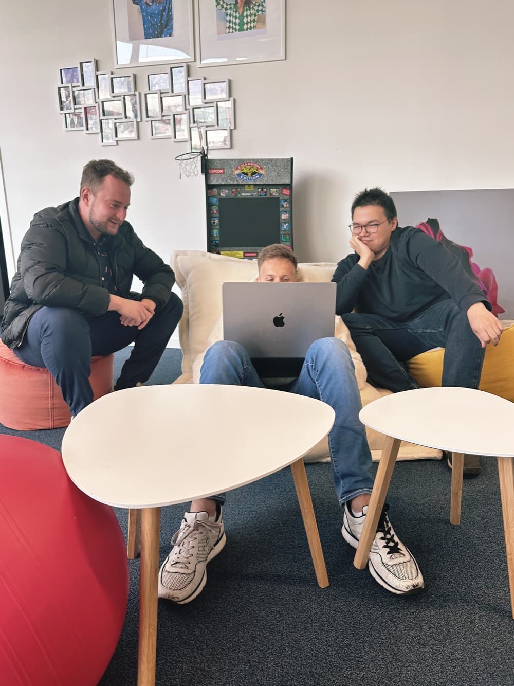 Three team members in front of a laptop, in the agency’s sofa corner.